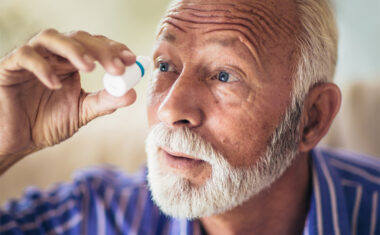 man using eye drops