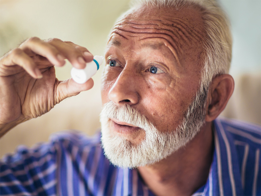 man using eye drops