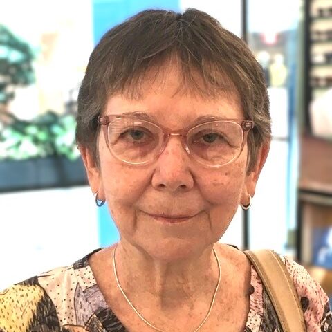 Mary Campbell. Mary is an older woman with short dark grey hair. She is wearing glasses and a printed shirt.