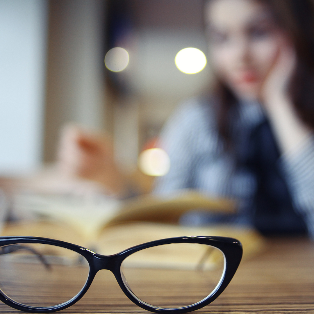 Glasses on table with woman blurred in the background