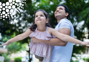 Father lifting young daughter with FBC iris in the sky.