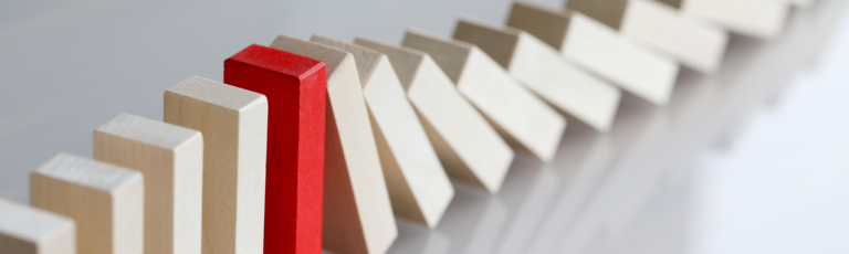 One red domino among other cream-coloured dominos